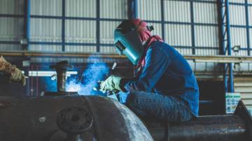 A person in full safety gear welds. 